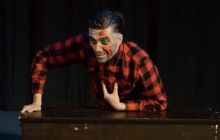 Simon Shaw as Ed Gein gestures with blood on his face
